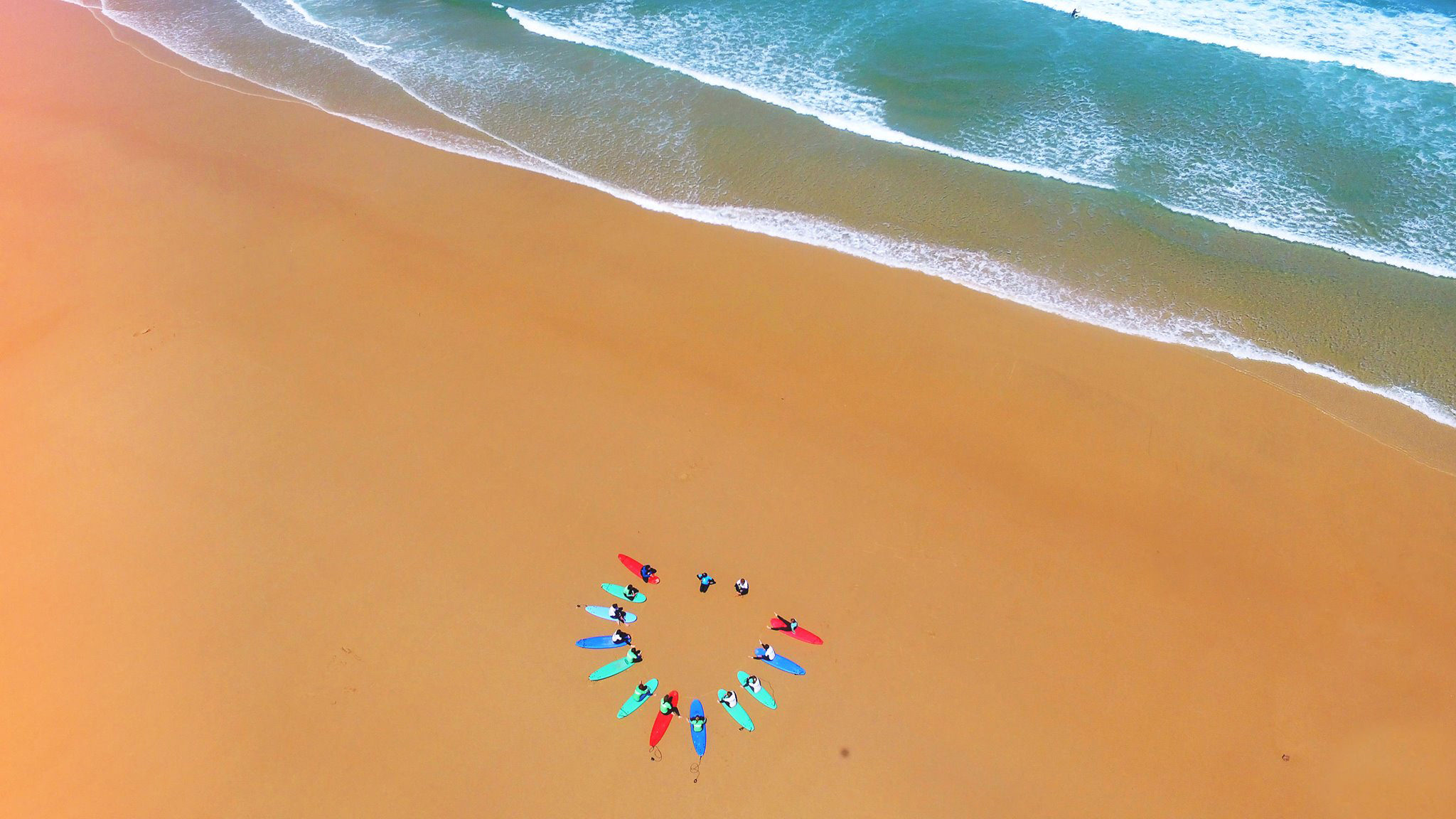 A drone shot of a SURF ACADEMIA lesson in Peniche