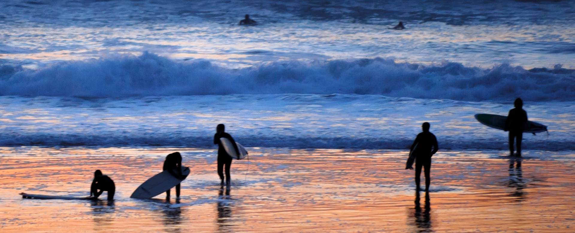 Sesja surfowania po zachodzie słońca w innym obozie surfingowym